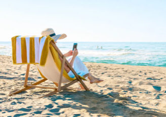 Frau im Liegestuhl am Strand, lesen | teilweise mit Ki generiert