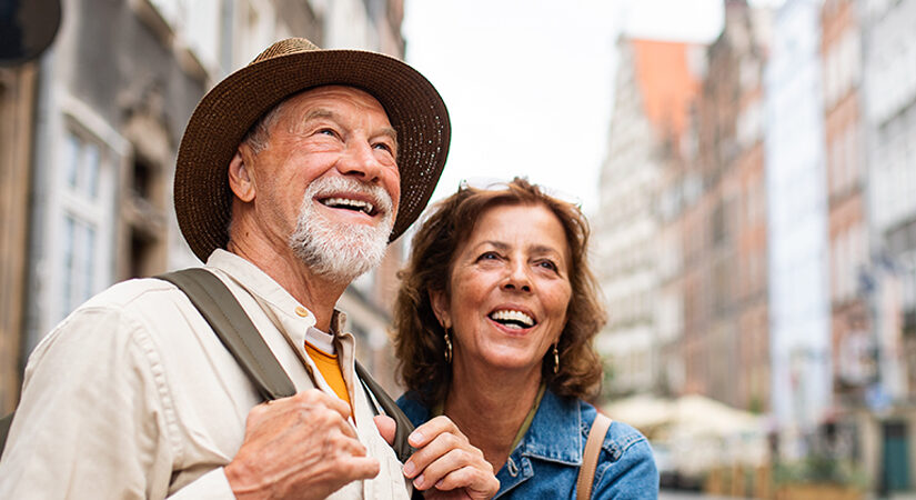 älteres Paar in einer Stadt, mit Rucksack, glücklich, Städtetrip