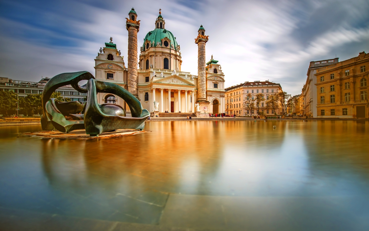 Blick auf st. Charles-Kirche am Karlsplatz in Wien. Langzeitbelichtungstechnik mit verschwommenen Wolken und glänzendem Wasser