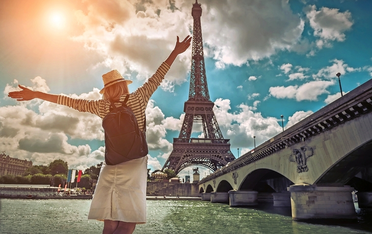© Andrii IURLOV - stock.adobe.com - Frau Touristen in der Nähe des Eiffelturms in Paris unter sunlig