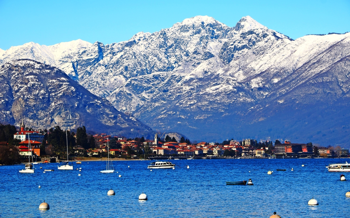 Winter in Baveno auf dem Lago Maggiore, der durch Schneeberge, Piemont Italien umgeben wird - © ClaraNila - stock.adobe.com