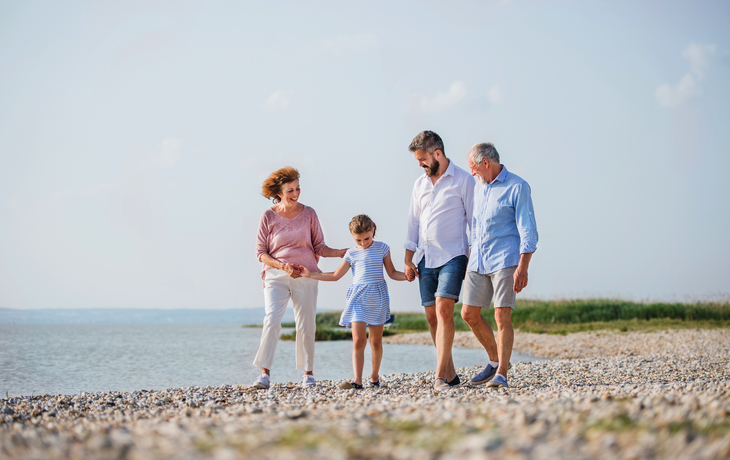 ©Halfpoint - stock.adobe.com - Mehrgenerationenfamilie im Urlaub am See