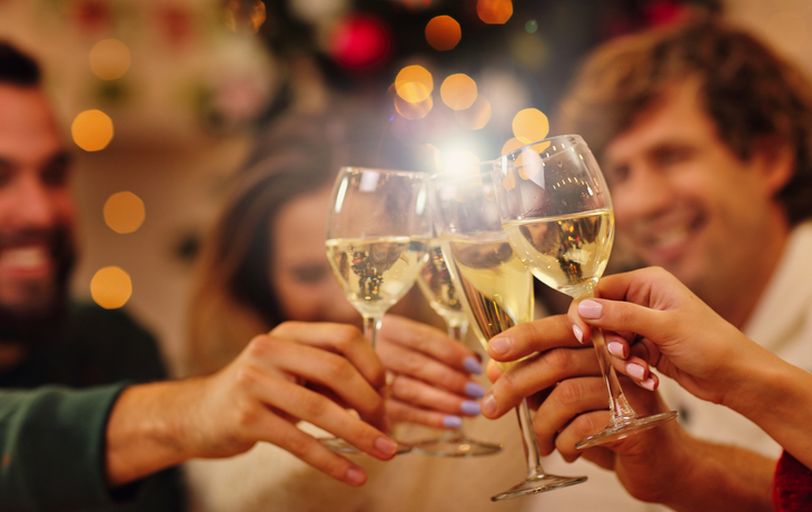 ©Kalim - stock.adobe.com - Gruppe von Freunden, die Weihnachten zu Hause feiern