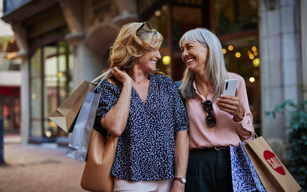 reife Frauen, die gemeinsam einkaufen gehen und sich dabei anschauen - © Rido - stock.adobe.com