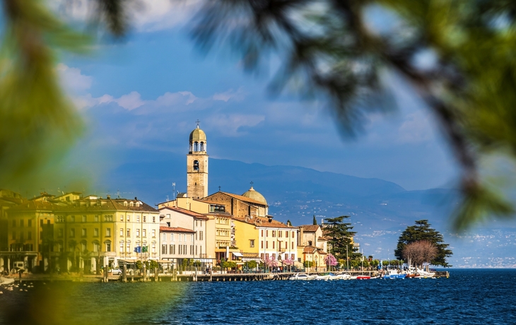 Burg am Wasser mit Booten und Bäumen bei sonnigem Himmel. - © Rene Hartmann - stock.adobe.com