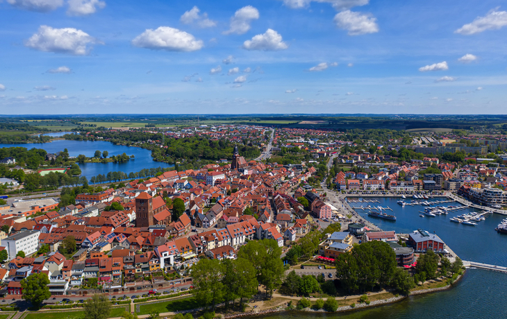 Aussicht auf die Stadt Waren an der Müritz in der Mecklenburgischen Seenplatte, mit roten Dächern, einem Hafen und umgebenden Seen. - © Tilo Grellmann - stock.adobe.com