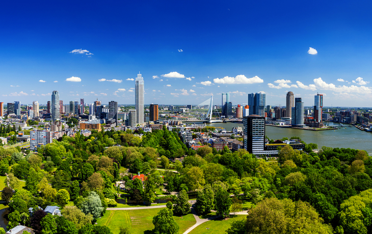 Park mit bunten Blumenbeeten, Bänken und Bäumen im Sonnenlicht. - © rois010 - stock.adobe.com