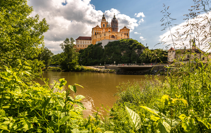 Barockes Kloster auf Hügel über Fluss, umgeben von Bäumen. - © kojin_nikon - stock.adobe.com
