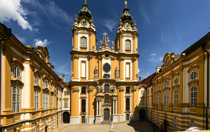 Barockes Kloster auf Hügel über Fluss, umgeben von Bäumen. - © kojin_nikon - stock.adobe.com
