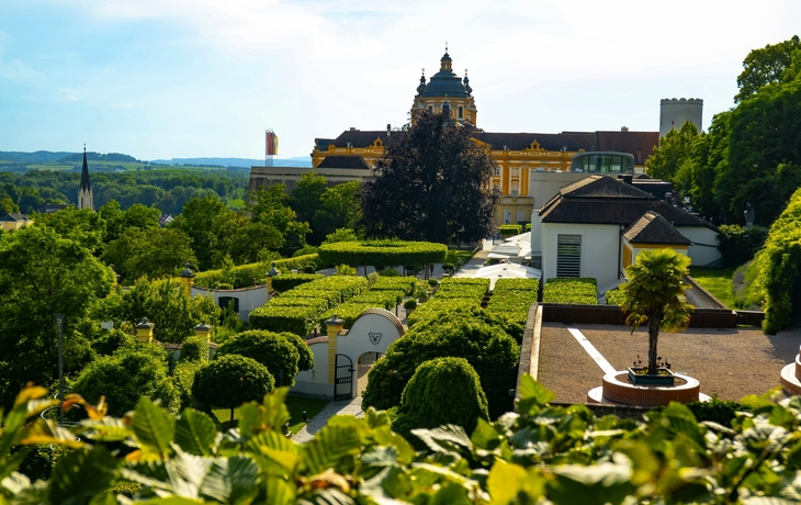 Barockes Kloster auf Hügel über Fluss, umgeben von Bäumen. - © kojin_nikon - stock.adobe.com