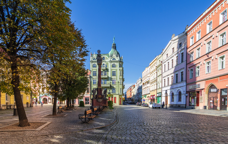 Städtischer Platz mit historischen Gebäuden und Bäumen an einem sonnigen Tag. - © Marcin - stock.adobe.com