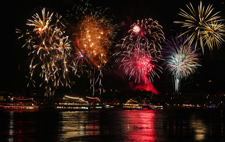 Feuerwerk über einem Fluss, beleuchtete Brücke bei Nacht. - © Harald Tedesco - stock.adobe.com