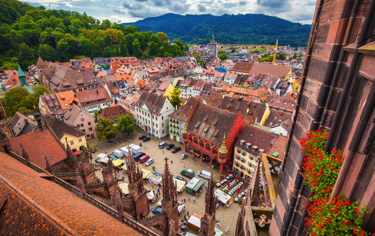 Blick auf bunte Gebäude und Marktplatz in einer Altstadt, umgeben von Hügeln. - © JFL Photography - stock.adobe.com