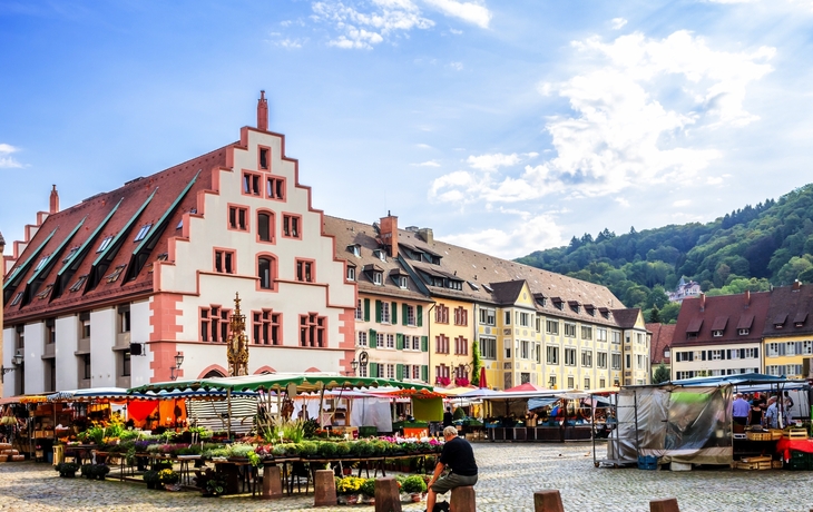 Blick auf bunte Gebäude und Marktplatz in einer Altstadt, umgeben von Hügeln. - © JFL Photography - stock.adobe.com