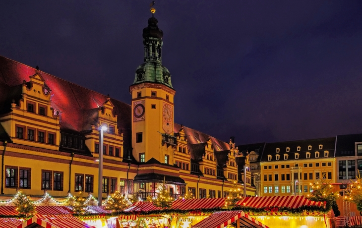 Weihnachtlich beleuchtetes historisches Gebäude bei Dämmerung, neben einem geschmückten Baum. - © chrishoppe.de - stock.adobe.com