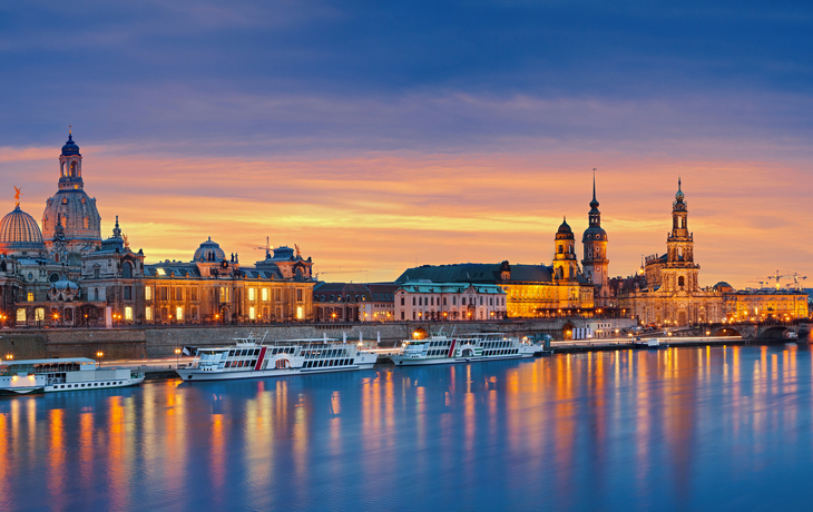Verschneite Stadtansicht mit historischen Gebäuden bei Sonnenuntergang. - © modernmovie - stock.adobe.com