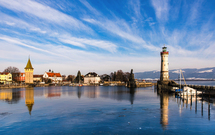 Nachtszene eines beleuchteten Weihnachtsmarktes mit Turm und Baumlichtern. - © hochfeld - stock.adobe.com