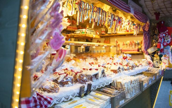 Menschen auf einem Weihnachtsmarkt vor einem historischen Gebäude bei Nacht. - ©e55evu - stock.adobe.com