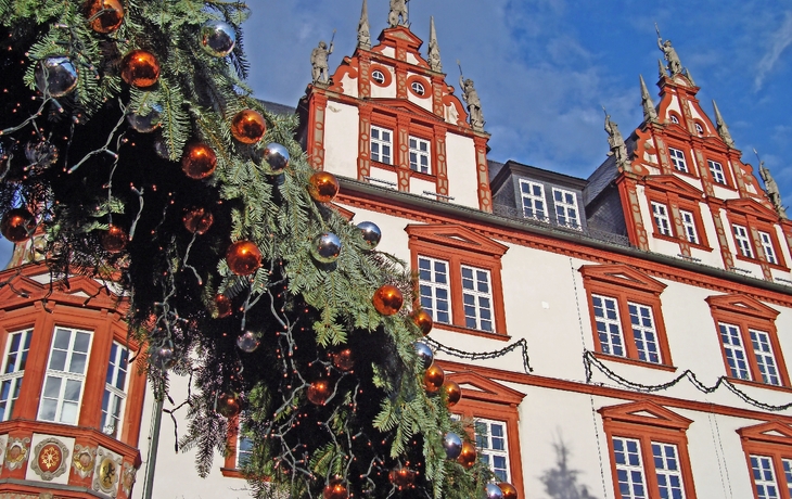 Verschneiter Platz bei Nacht mit beleuchteten Gebäuden und Weihnachtsbaum. - © val thoermer/EyeEm - stock.adobe.com