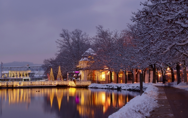 Steinstatue eines Drachen und eines Mannes vor historischer Gebäudekulisse. - © EKH-Pictures - stock.adobe.com