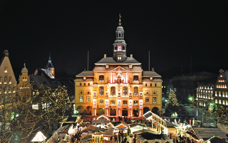 Weihnachtsbaum mit Lichtern in einer verschneiten Stadt bei Nacht - © m. letschert - stock.adobe.com