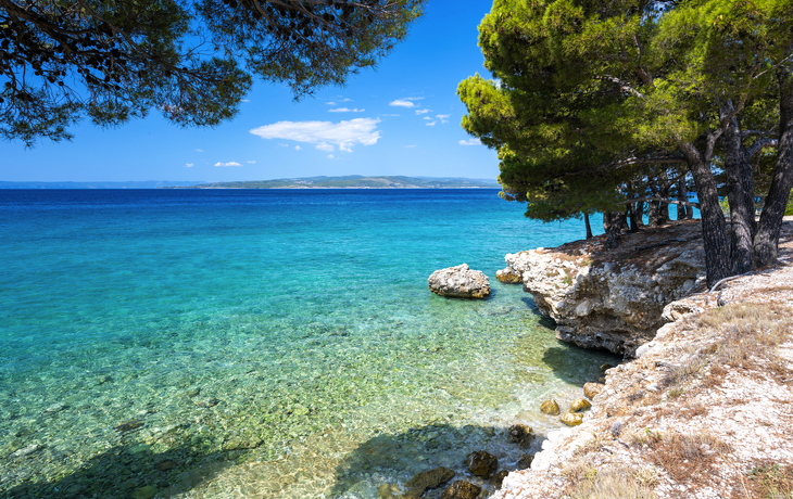 Malerische Küstenlandschaft mit Strand und Booten, umgeben von klarem, türkisblauem Wasser. - © kite_rin - stock.adobe.com