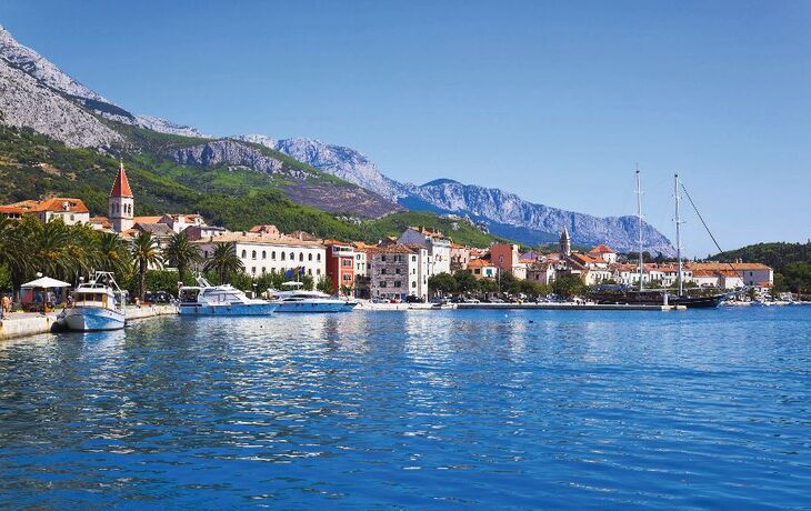 Malerische Küstenlandschaft mit Strand und Booten, umgeben von klarem, türkisblauem Wasser. - © kite_rin - stock.adobe.com