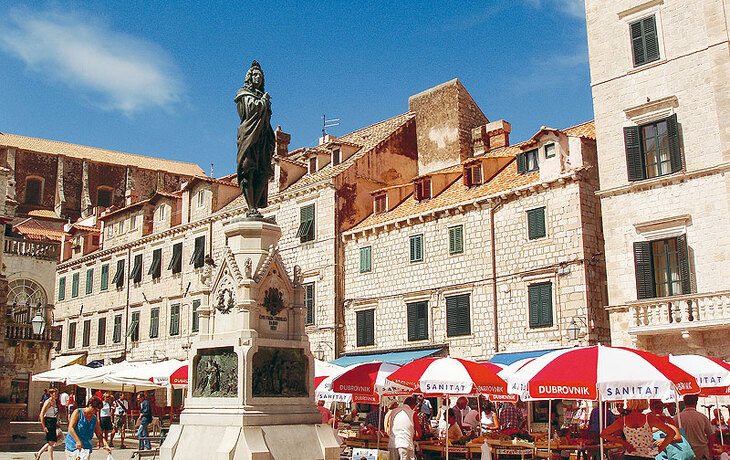 Historische Kirche auf einem gepflasterten Platz bei klarem Himmel. - © Roman Babakin - stock.adobe.com