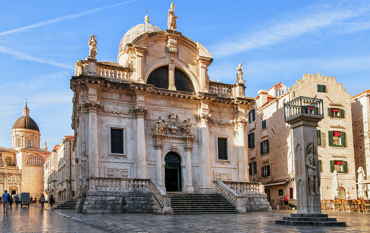 Historische Kirche auf einem gepflasterten Platz bei klarem Himmel. - © Roman Babakin - stock.adobe.com