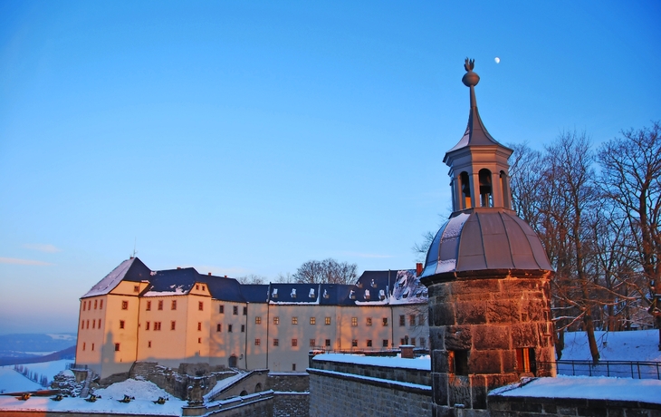 Dorf im Winter von oben, mit Fluss und bewaldeten Hügeln im Hintergrund. - © Sliver - stock.adobe.com