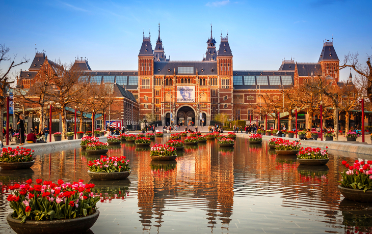 Kanalanlage in Amsterdam mit bunten Blumen und traditionellen Häusern im Hintergrund. - © Nikolay N. Antonov - stock.adobe.com