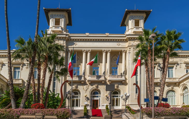 Historisches Gebäude mit Flaggen und Palmen. - © PRILL Mediendesign - stock.adobe.com