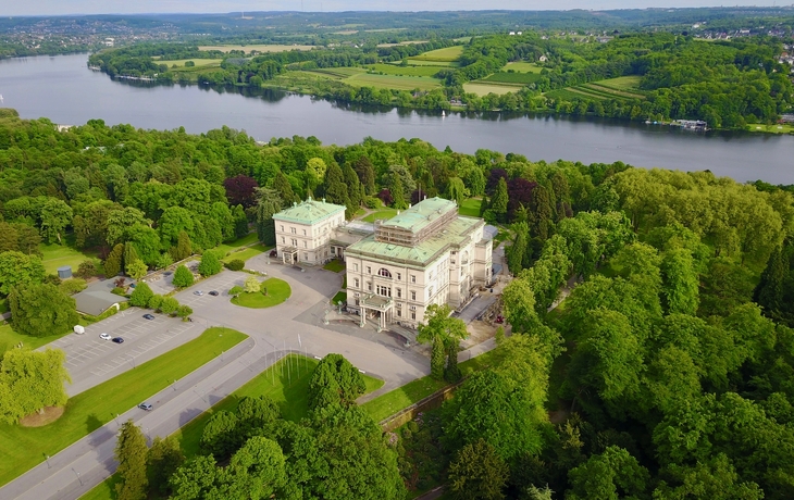 Großes historisches Gebäude mit Säulen und Pflanzen im Vordergrund. - © Udo Kruse - Fotolia