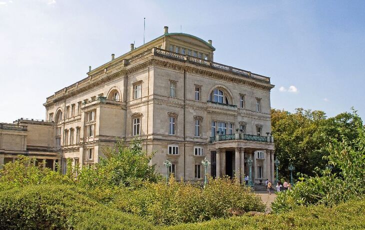 Großes historisches Gebäude mit Säulen und Pflanzen im Vordergrund. - © Udo Kruse - Fotolia