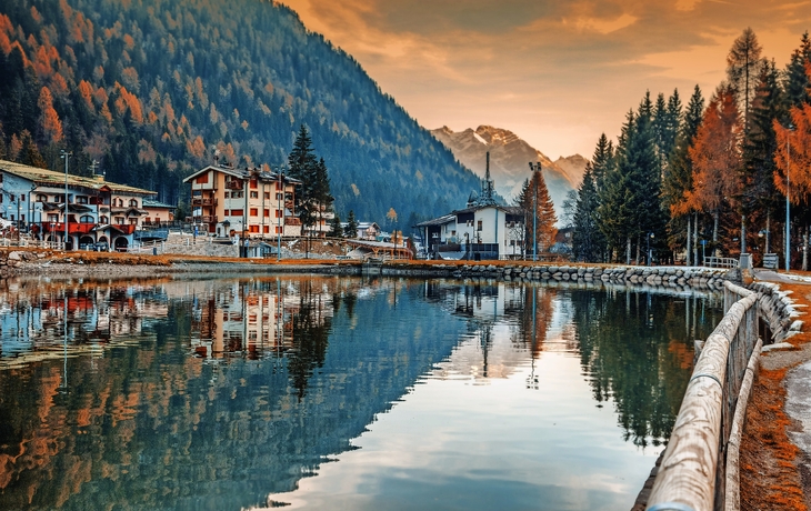 Berglandschaft mit See, Wiese, Bäumen und geparkten Autos unter bewölktem Himmel. - ©pacolinus - stock.adobe.com