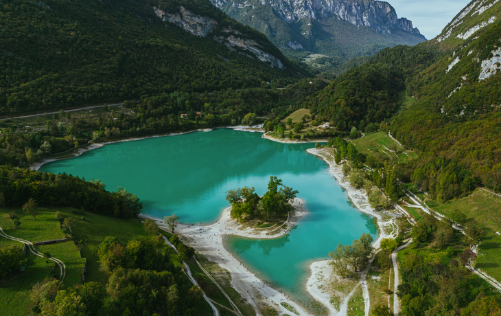 Bergsee mit türkisblauem Wasser, umgeben von grünen Bergen und Wäldern. - © Lukasz - stock.adobe.com