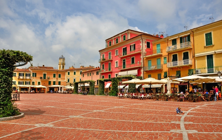 Bunte Häuser und Boote am Hafen vor einer hügeligen Landschaft - © e55evu - stock.adobe.com
