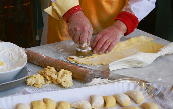 Einige rohe Tortellini mit frischen Kräutern auf einem Holztisch. - © quipu - Fotolia