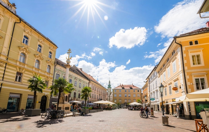Steinstatue eines Drachen und eines Mannes vor historischer Gebäudekulisse. - © EKH-Pictures - stock.adobe.com