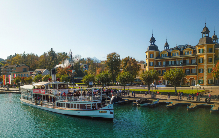 Steinstatue eines Drachen und eines Mannes vor historischer Gebäudekulisse. - © EKH-Pictures - stock.adobe.com
