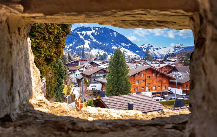 Alpenstraße mit traditionellen Holzhäusern und Kirche bei sonnigem Wetter - © Bogdan Lazar - stock.adobe.com