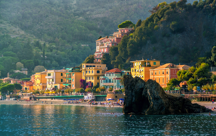 Bunte Häuser von Riomaggiore an der felsigen Küste Italiens unter blauem Himmel. - ©Warpedgalerie - stock.adobe.com