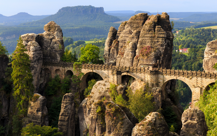 Eine steinerne Brücke zwischen Felsformationen in einer bewaldeten Landschaft. - © andiz275 - stock.adobe.com