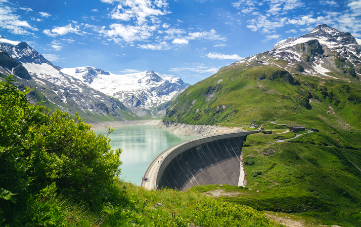 Staumauer in alpiner Landschaft mit See und schneebedeckten Bergen im Hintergrund. - © serkat Photography - stock.adobe.com
