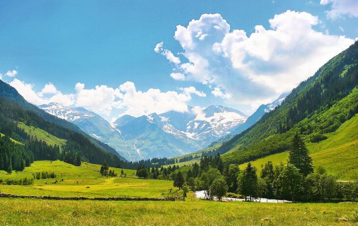 Wasserfall in einem Waldgebiet unter blauem Himmel und Sonne. - © Comofoto - stock.adobe.com