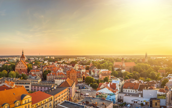 Stadtansicht mit Kirche und Fluss bei Sonnenuntergang aus der Vogelperspektive - © uslatar - stock.adobe.com