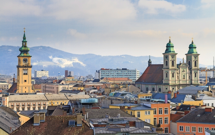 Stadtpanorama mit Kirchtürmen und Bergen im Hintergrund. - © Zechal - Fotolia