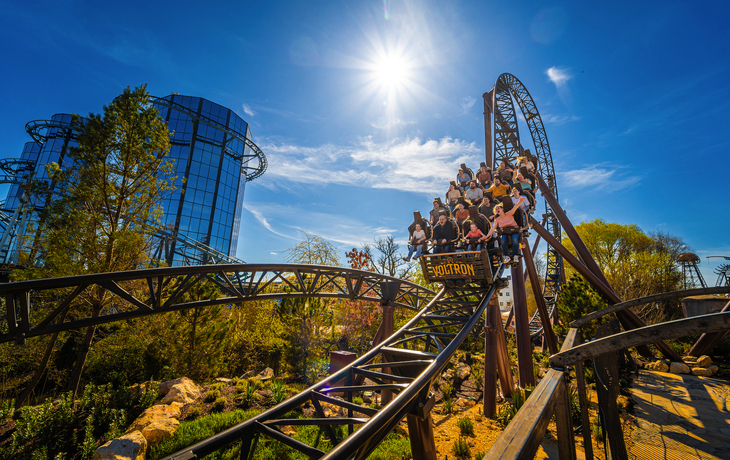 Achterbahn in einem Freizeitpark, voll besetzter Zug, sonniger Tag. - Europa-Park